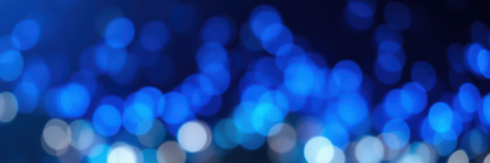 Vibrant blue bokeh lights create a mesmerizing backdrop for an evening celebration at a festive gathering